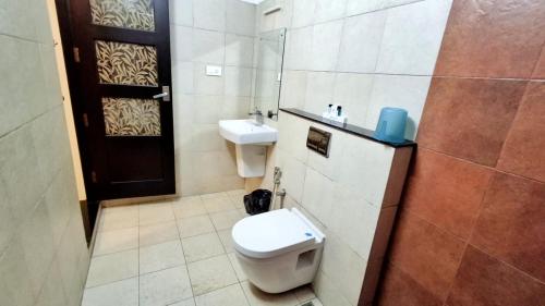 a bathroom with a toilet and a sink at Hotel Wayanad Gate in Wayanad