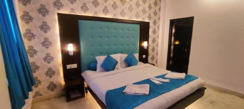 a bedroom with a large bed with blue and white pillows at Hotel Mandiram Palace in Udaipur