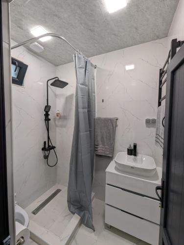 a white bathroom with a shower and a sink at Erevanyan House in Pʼarakʼar