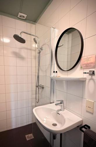 a white bathroom with a sink and a mirror at Hotel Restaurant 't Ronde Loegh in Winschoten
