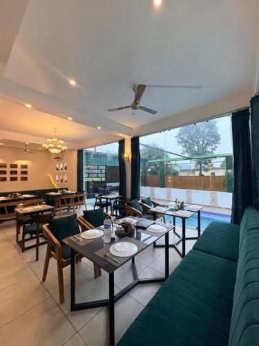 a restaurant with couches and tables and a large window at Lagoon Bites in Jhājra