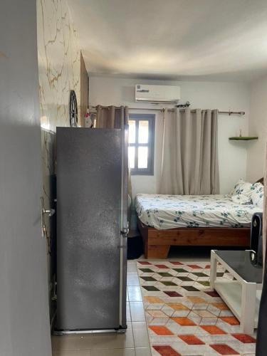 a room with a refrigerator and a bed in it at Studio Angre Mahou in Cocody