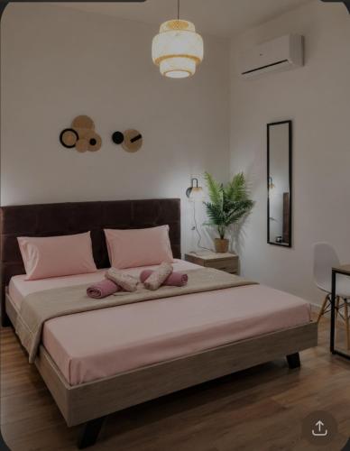 a bedroom with a large bed with pink pillows at AGGELIKI STUDIOS in Agios Georgios
