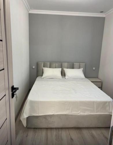 a bed with white sheets and pillows in a bedroom at Erevanyan House in Pʼarakʼar