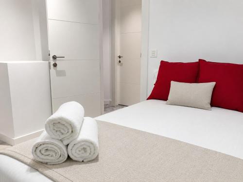 a bedroom with a white bed with towels on it at Smart-Tech Plaza Apartment in Salamanca