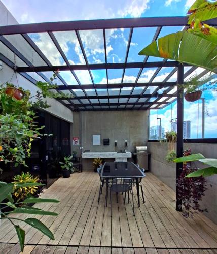 a patio with a table on a wooden deck at Apartamento Moderno Cosmopolitan Tower in San José