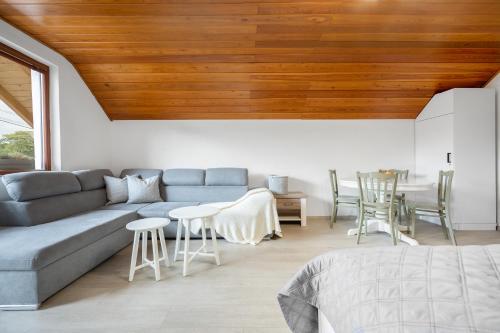a living room with a couch and a table and chairs at Apartmán Pure Harmony in Velké Bílovice