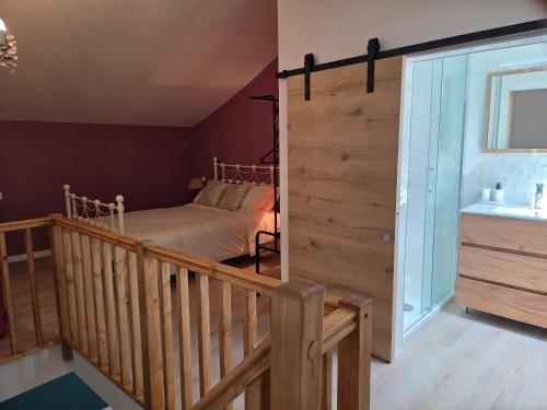 a bedroom with a bed and a staircase with a sink at Lazy Days Gite in Rancon