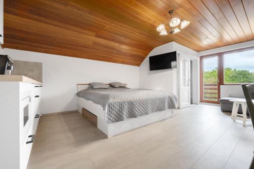 a bedroom with a bed and a wooden ceiling at Apartmán Pure Harmony in Velké Bílovice