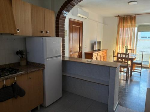 a kitchen with a white refrigerator and a dining room at Apartamentos turisticos los baños in Fortuna