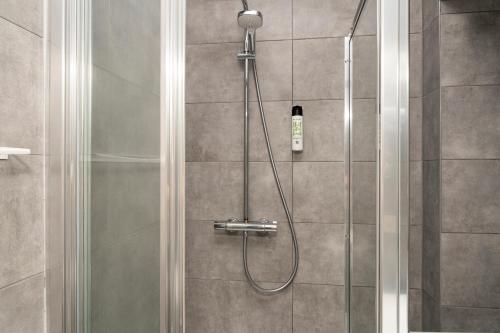 a shower with a shower head in a bathroom at Miki Stays - 700m zum Ring in Vienna
