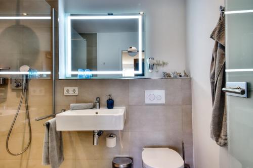 a bathroom with a sink and a toilet at Ferienwohnung Buntspecht 31 im Wreecher Idyll Rügen by ruyastay in Putbus
