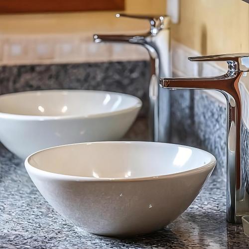 two white bowls on a counter with a faucet at Pousada Ritmos da Terra - Estadia de 6ª a Domingo in Angelina