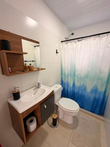 a bathroom with a toilet and a sink and a shower at Apartamento El Arrayán in Tacuarembó