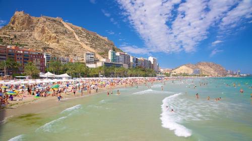 a beach with a bunch of people in the water at Explanada Beach Deluxe Flat in Alicante