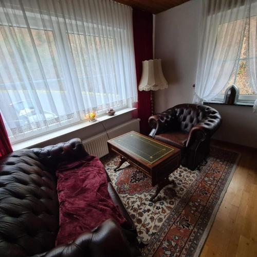 a living room with a leather couch and a coffee table at Haus Nummer 7 in Manderscheid