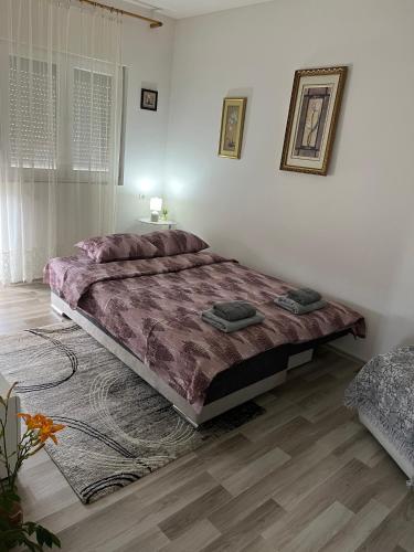 a bedroom with a large bed and a wooden floor at Sumski Kutak in Valjevo