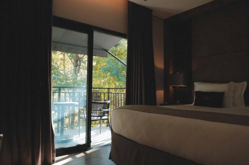 a bedroom with a bed and a view of a balcony at Pousada Murano in Campos do Jordão