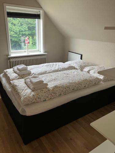 a bedroom with a large bed with towels on it at Lejlighed i Soldalen in Sindal