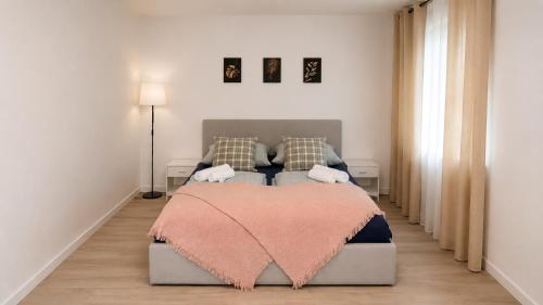 a bedroom with a bed with a pink blanket on it at Koblenz Corner Rooms in Koblenz