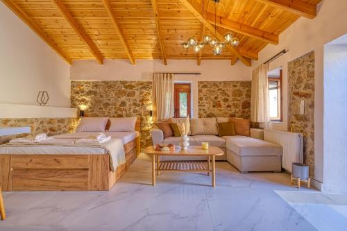 a bedroom with a bed and a couch and a table at Thymele Stone House in Lygourio