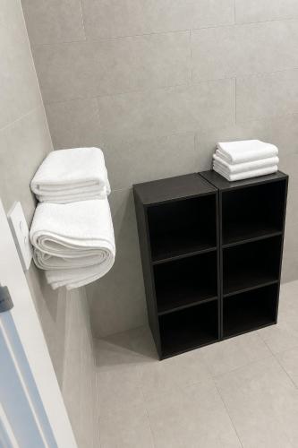 a bathroom with a black shelf and towels at Stadium View Retreat at Olympic Park in Sydney