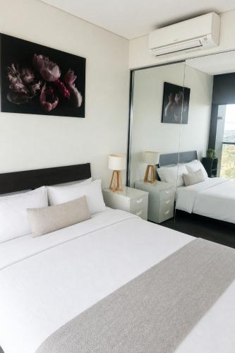 a bedroom with two beds and a mirror at Stadium View Retreat at Olympic Park in Sydney