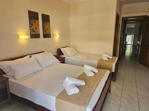 two beds in a hotel room with towels on them at Philippos Hotel in Paralia Katerinis