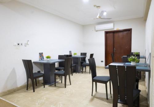 a dining room with tables and chairs in a room at Maya Lodge in Accra