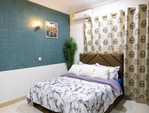 a bedroom with a bed and a green wall at Maya Lodge in Accra