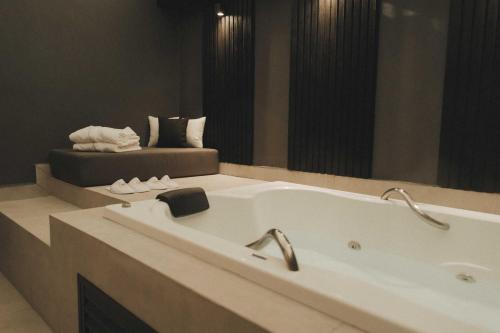 a bath tub in a bathroom with a large mirror at Pousada Murano in Campos do Jordão