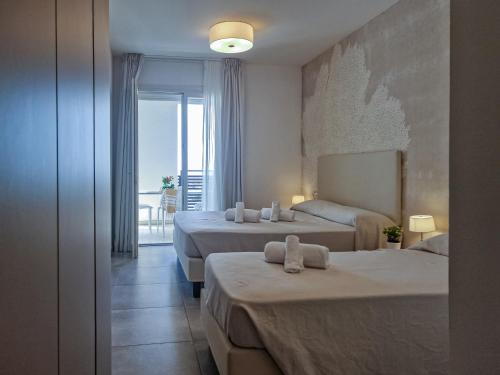 a hotel room with two beds and a balcony at Ashanti Aparthotel Wellness&Spa in Bibione