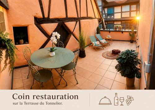 a patio with a table and chairs in a building at La Terrasse du Tonnelier - 92m2 - plein centre médiéval - sauna - terrasse 20m2 - garage in Kaysersberg