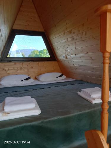 a bed in a wooden cabin with a window at Akhateli in Ruispiri