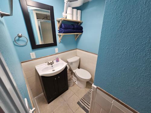 a blue bathroom with a sink and a toilet at The Cottonwood Den in Laramie