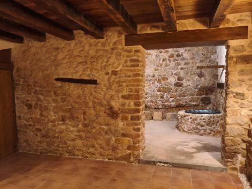 a room with a stone wall and a stone tub at Casa Les Donfelises in Peñarroya de Tastavins