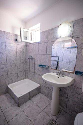 a bathroom with a sink and a shower and a tub at Vila Randunica in Eforie Sud
