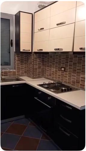 a kitchen with white cabinets and a stove at Adriatic Pearl Apartamets in Lezhë