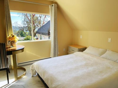 a bedroom with a bed and a large window at UVIC Ocean View Private Guesthouse in Victoria