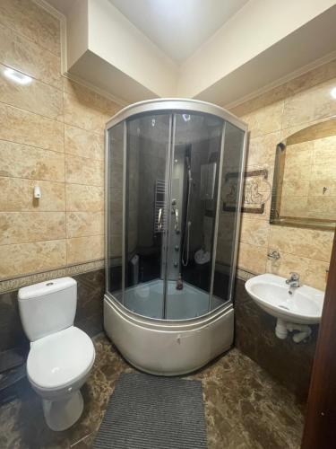 a bathroom with a shower and a toilet and a sink at Міраж in Uzhhorod