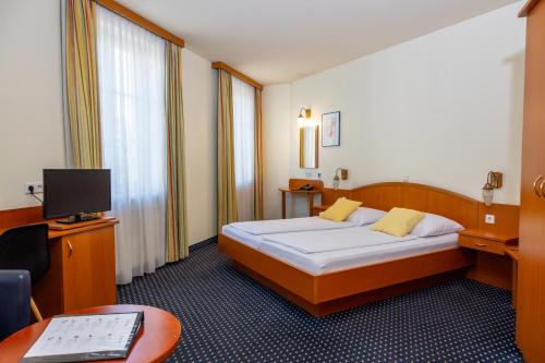 a hotel room with a bed and a desk at Suite Hotel 900m zur Oper in Vienna