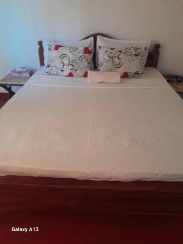 a large white bed with two pillows on it at Dad's Inn by Wee Group in Andiambalama