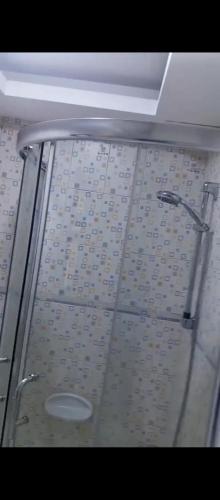 a glass shower door in a bathroom with a shower head at دوار الهلال دوار الثقافه in Irbid