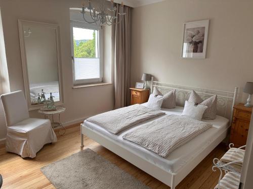 a bedroom with a bed and a chair and a window at Haus 1a in Lauterecken