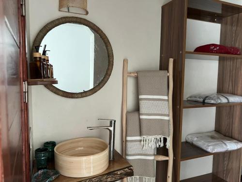 a bathroom with a sink and a mirror and towels at Villa TaouBa in Ghazoua