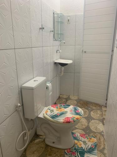 a bathroom with a toilet with a mirror and a sink at Pousada Praiamar in Beberibe