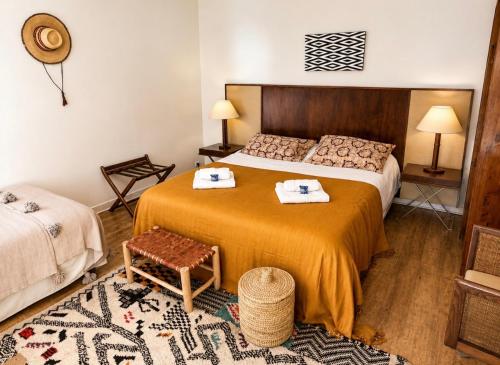 a bedroom with a bed with two towels on it at Maison d'hôtes Villa Meinga in Saint-Coulomb