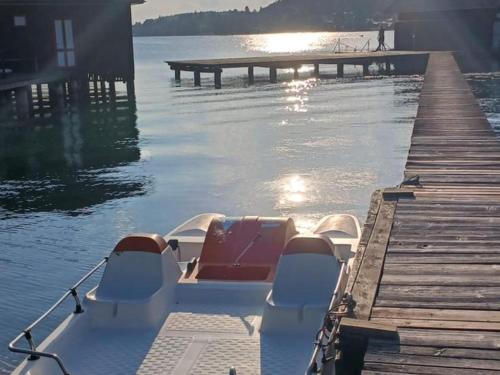 a boat parked next to a dock on the water at Ferienpension Garni in Sankt Kanzian