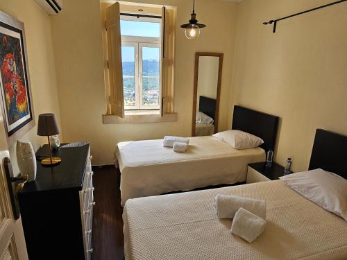 a hotel room with two beds and a window at Quinta do Penedo- Refúgio de Charme e Natureza in Ferreira do Zêzere