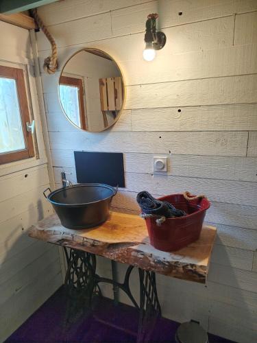 a bathroom with a sink and a mirror on a table at La tiny house in Bissières